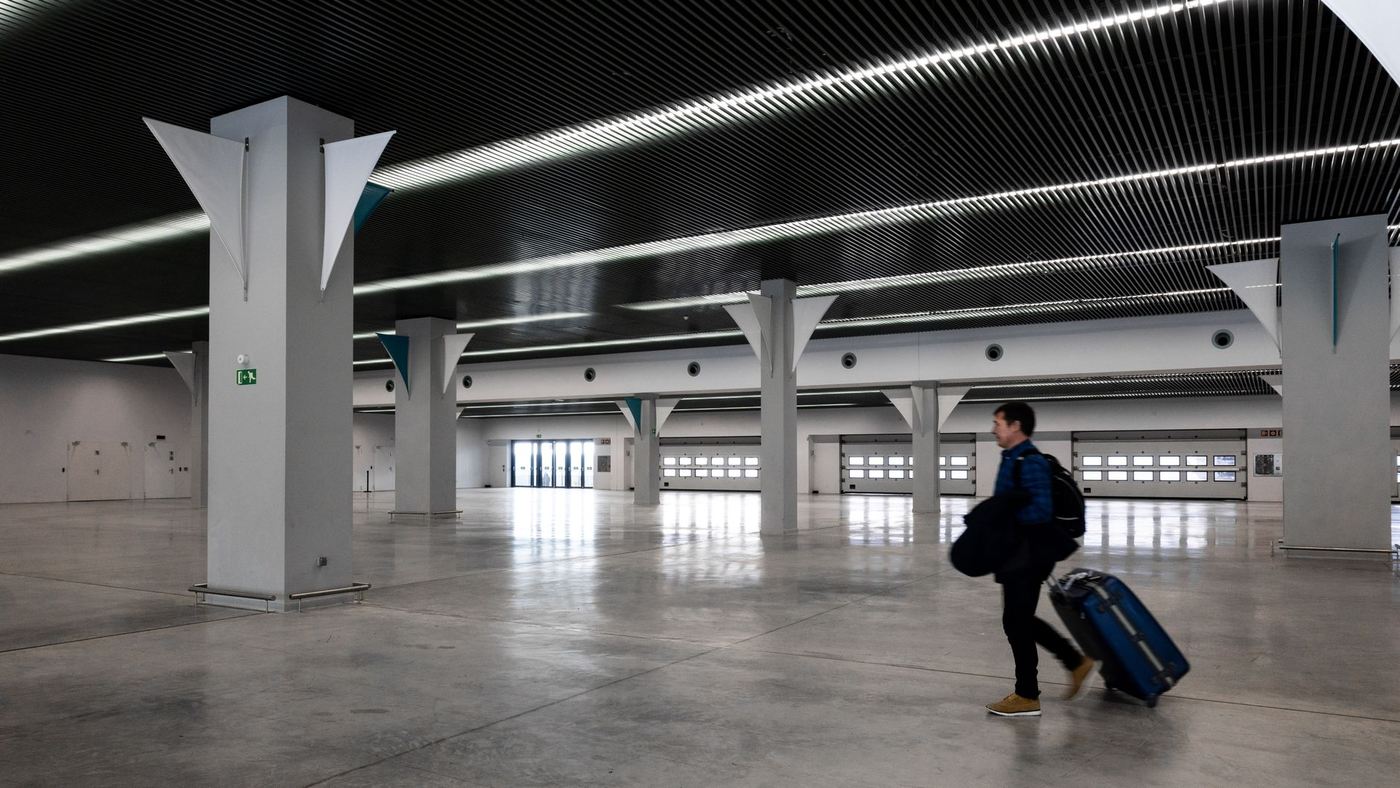Voyageur et sa valise dans un hall d’aéroport